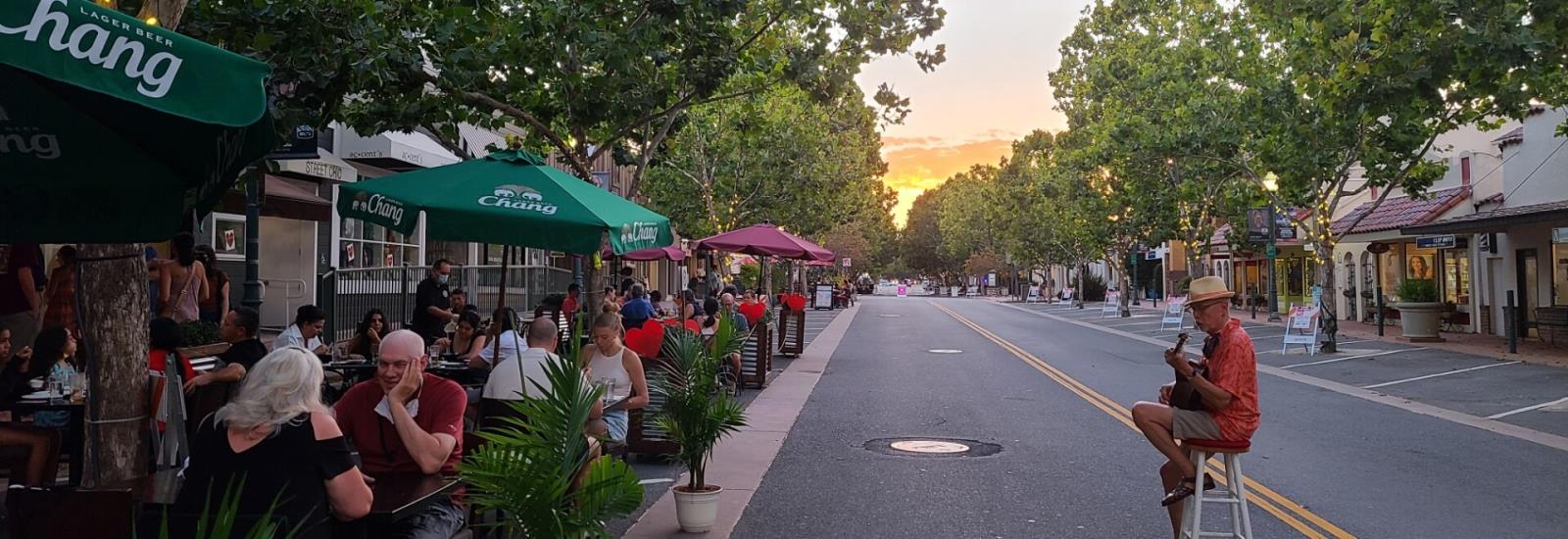 man playing guitar to diners on Grant Ave